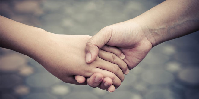 One hand holding another