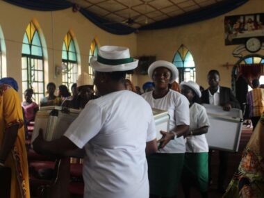 7-16-4 Usher carrying collection boxes down isle of church