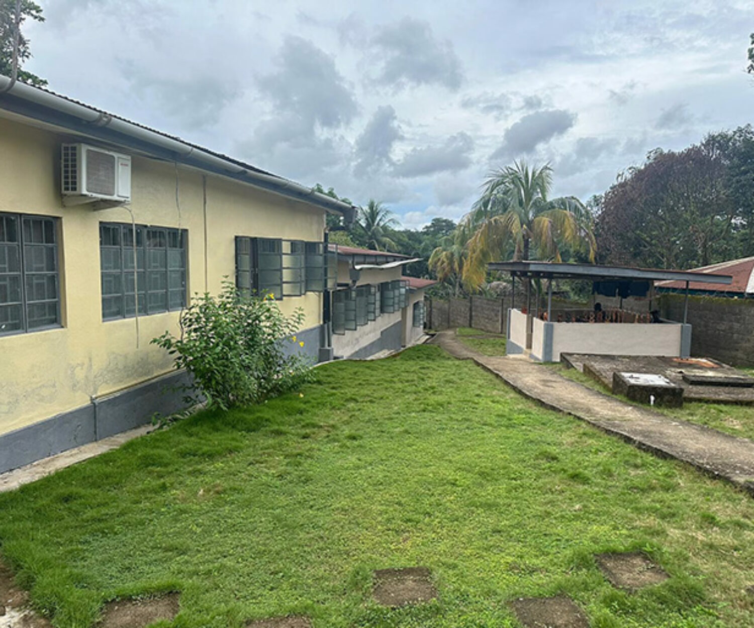 Yellow building with shrub on side of it.
