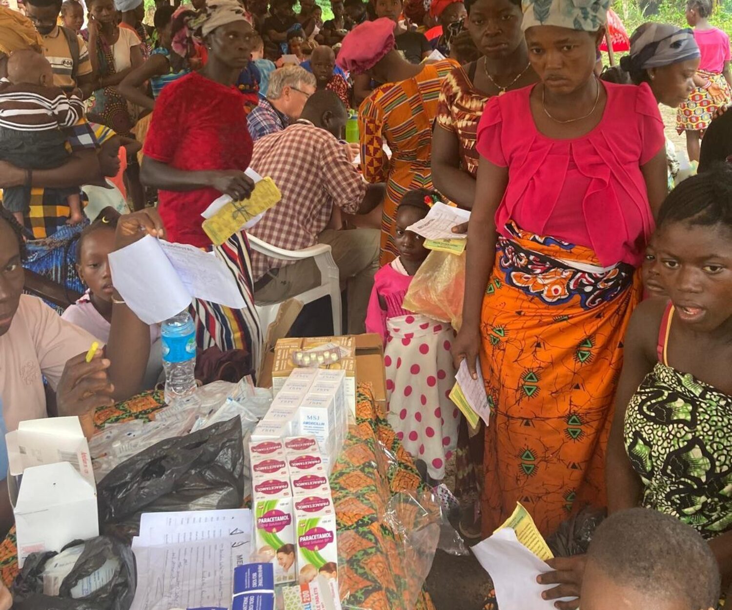 The village of Fengehun gathered for care under tent.