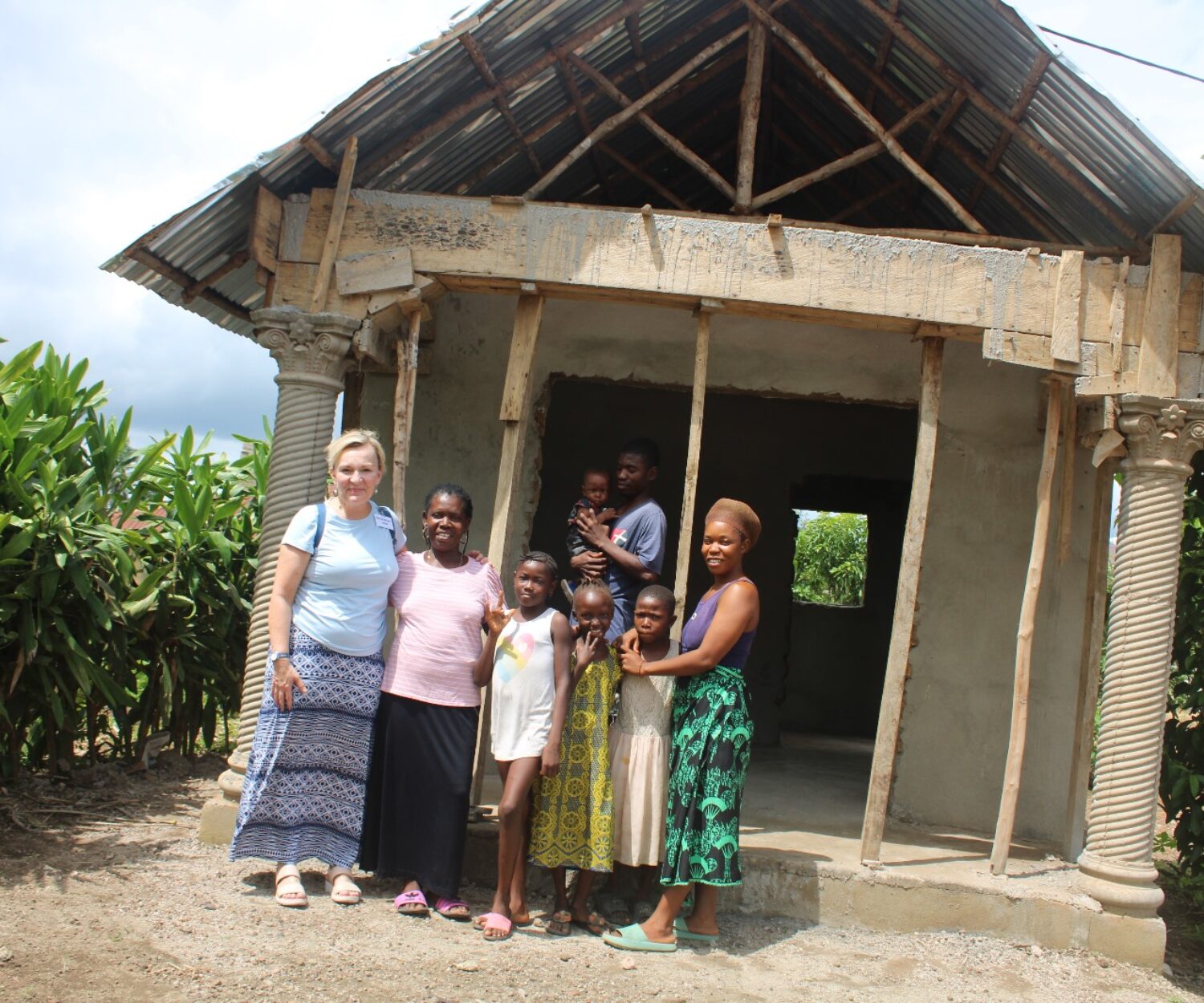 Rev. Gina and the Harding family standing in front of home